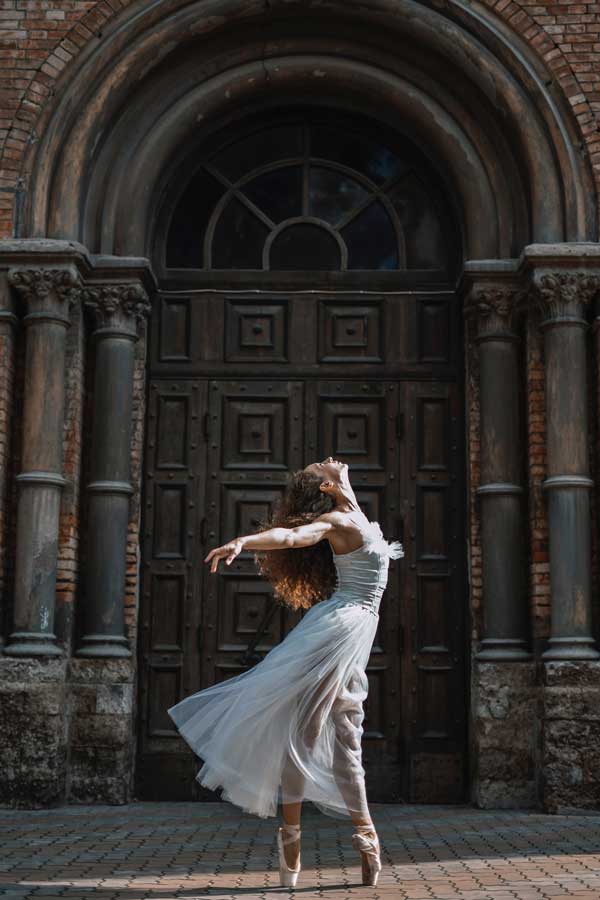 classical dancer in front of an old building