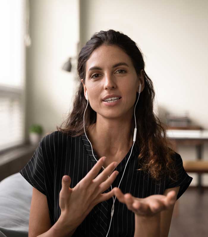 portrait d'une jeune femme confiante et portant des écouteurs pendant une visioconférence